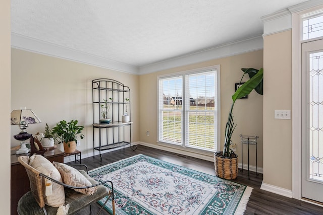 sitting room featuring ornamental molding, dark wood-style flooring, a textured ceiling, and baseboards