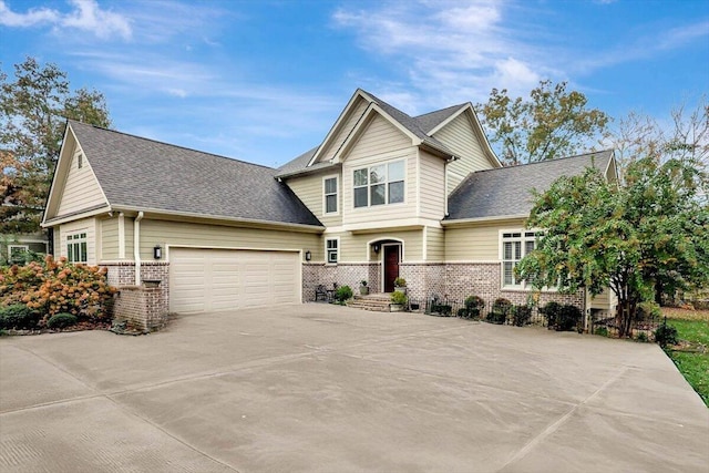 craftsman-style home with a garage, driveway, a shingled roof, and brick siding