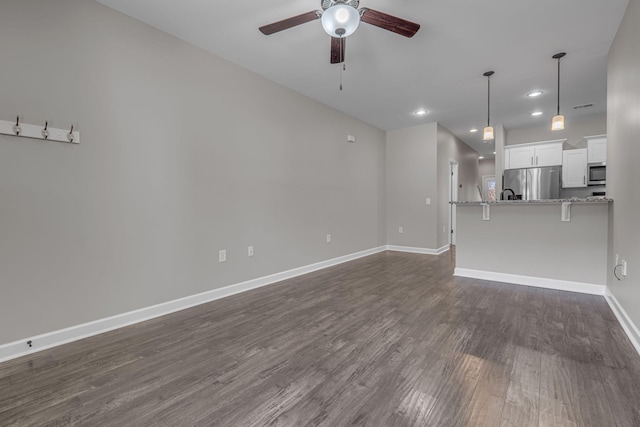 unfurnished living room featuring dark wood-style floors, recessed lighting, visible vents, a ceiling fan, and baseboards