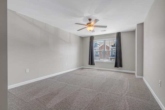 spare room with a ceiling fan, carpet, visible vents, and baseboards