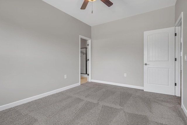 spare room featuring carpet floors, a ceiling fan, and baseboards