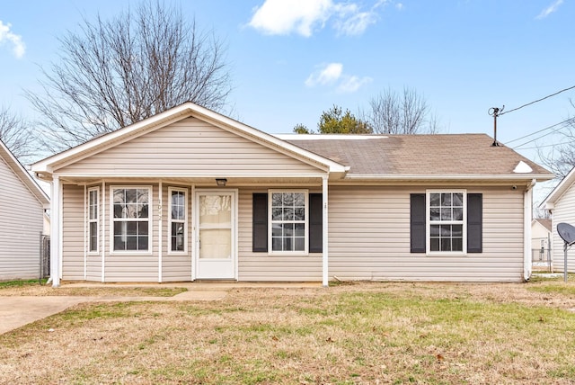 single story home featuring a shingled roof and a front lawn