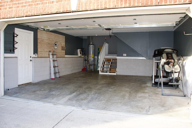 garage featuring concrete block wall and water heater