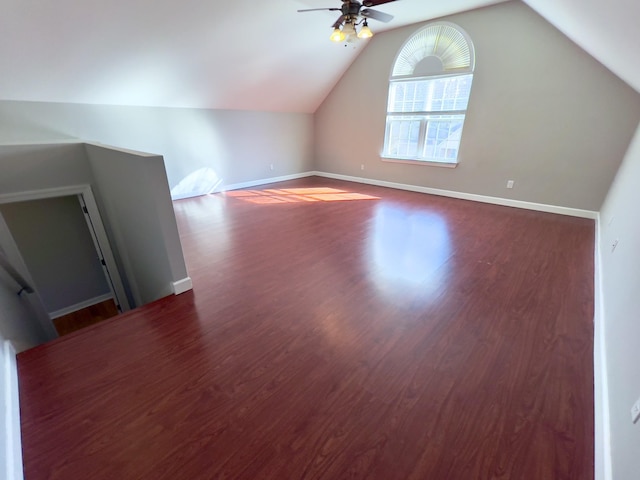 bonus room with a ceiling fan, lofted ceiling, dark wood-style flooring, and baseboards