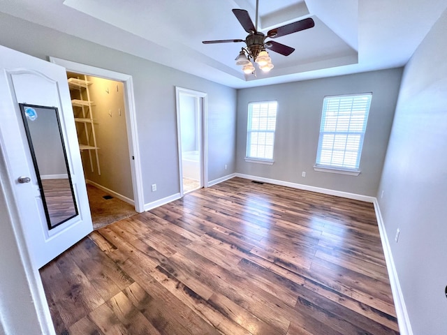 spare room featuring baseboards, a raised ceiling, and wood finished floors