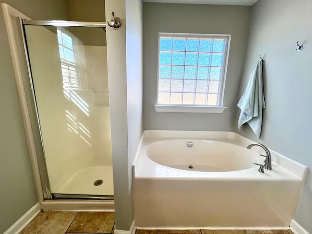 bathroom featuring a stall shower, tile patterned flooring, and a bath