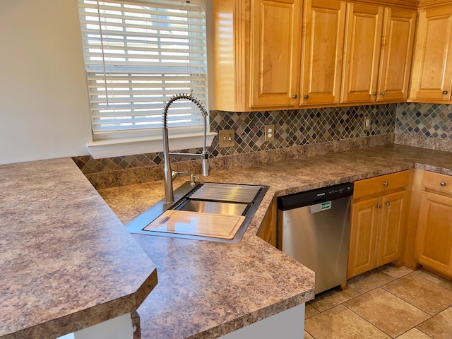 kitchen featuring dishwasher, backsplash, and a sink