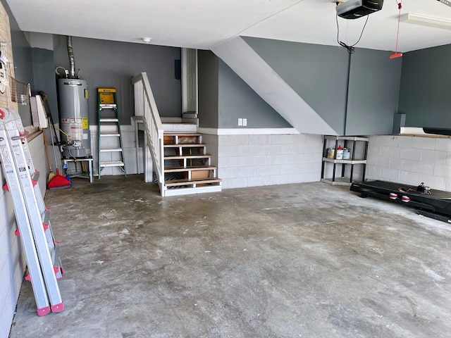 garage with water heater, concrete block wall, and a garage door opener