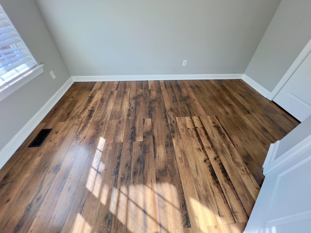 interior details featuring wood finished floors, visible vents, and baseboards