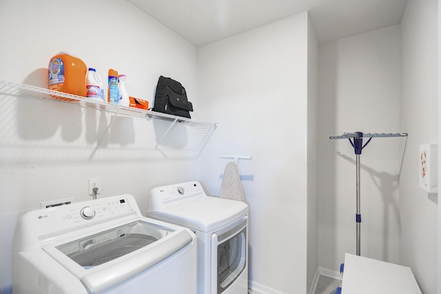 laundry area with laundry area, baseboards, and separate washer and dryer