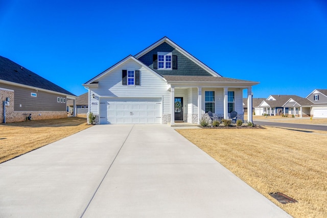 view of front of home featuring a garage, concrete driveway, stone siding, covered porch, and a front lawn