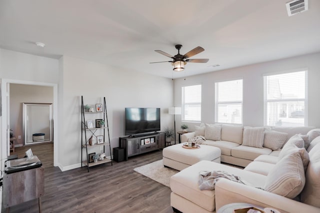 living room featuring a ceiling fan, baseboards, visible vents, and dark wood-style flooring