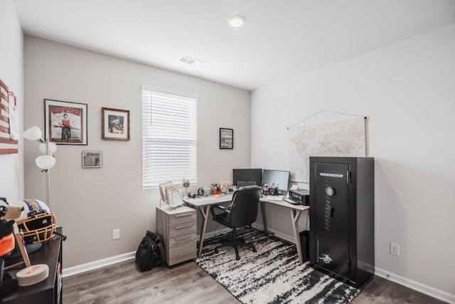 office area with visible vents, baseboards, and wood finished floors