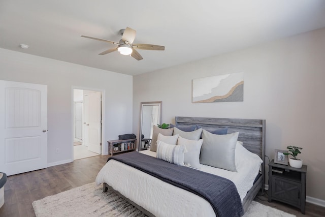 bedroom with ensuite bath, wood finished floors, a ceiling fan, and baseboards