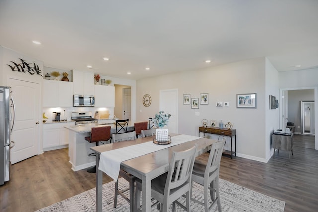 dining room with recessed lighting, baseboards, and wood finished floors