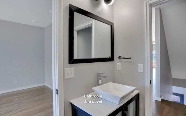 bathroom featuring wood finished floors, vanity, and baseboards