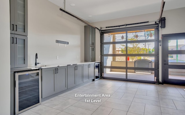 interior space with beverage cooler, light tile patterned floors, and a sink