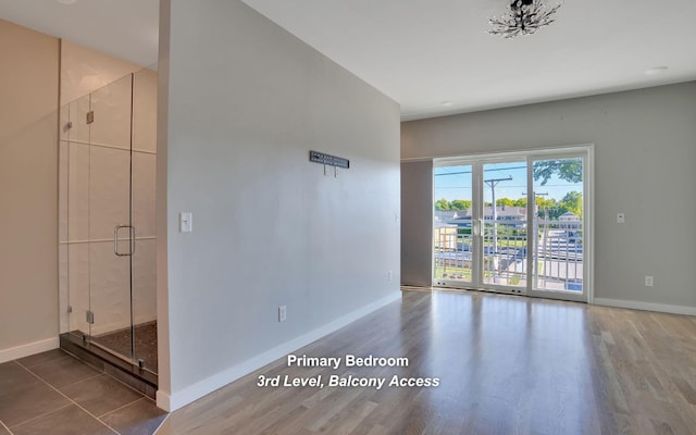 spare room featuring baseboards and wood finished floors