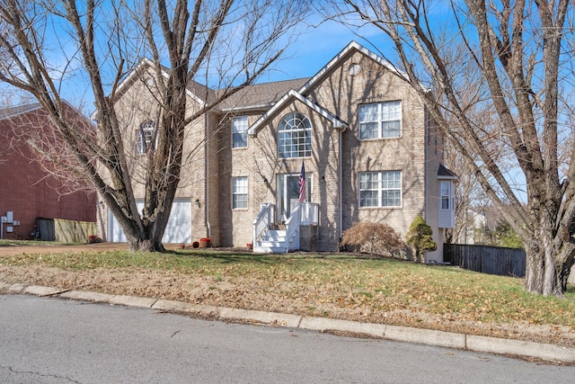 traditional-style home with a garage, brick siding, fence, driveway, and a front lawn