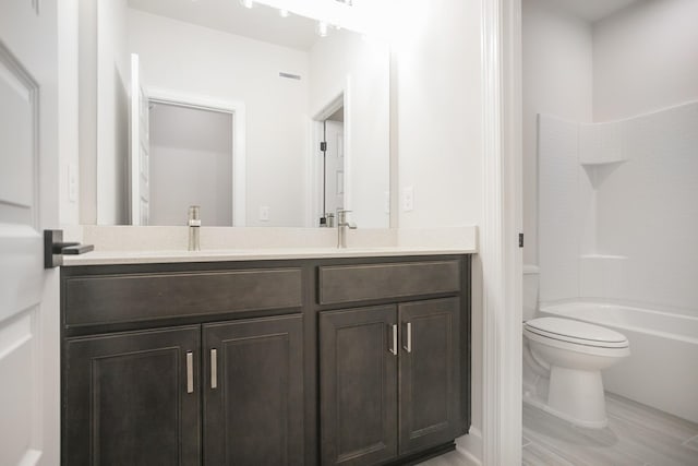 bathroom with double vanity, toilet, a sink, and shower / bathing tub combination