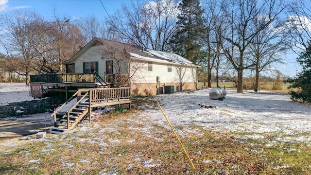 view of side of property featuring stairs, brick siding, cooling unit, and a wooden deck