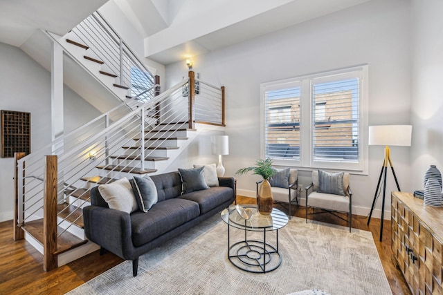 living area featuring stairs, wood finished floors, and baseboards