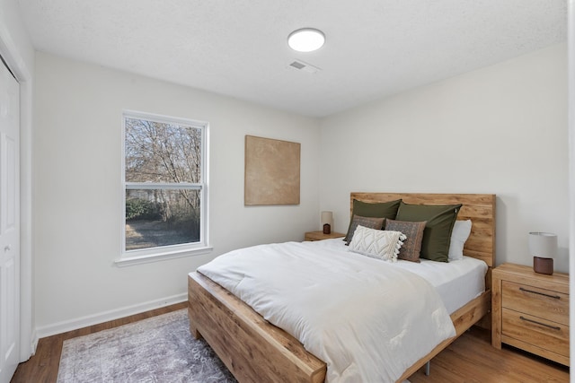 bedroom featuring visible vents, dark wood finished floors, and baseboards