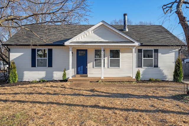 view of front of property featuring a shingled roof and a front lawn