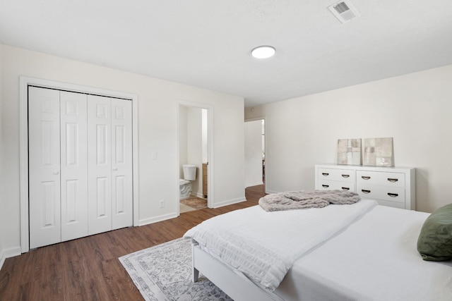 bedroom with baseboards, visible vents, dark wood-style floors, ensuite bath, and a closet