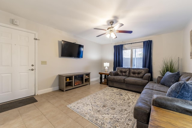 living area with baseboards, a ceiling fan, and light tile patterned flooring