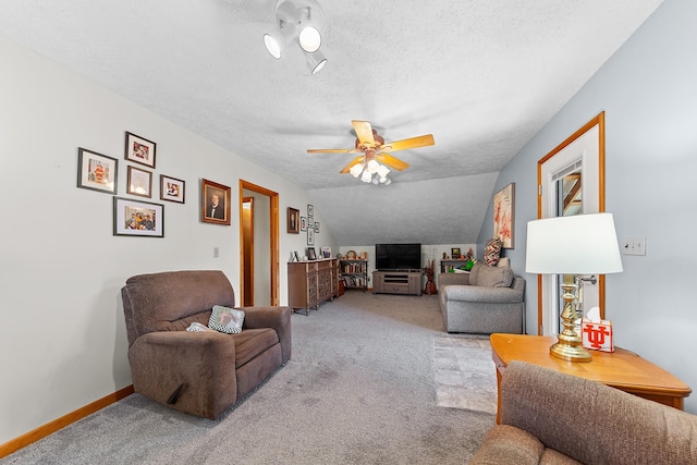 living room with a textured ceiling, ceiling fan, lofted ceiling, light colored carpet, and baseboards