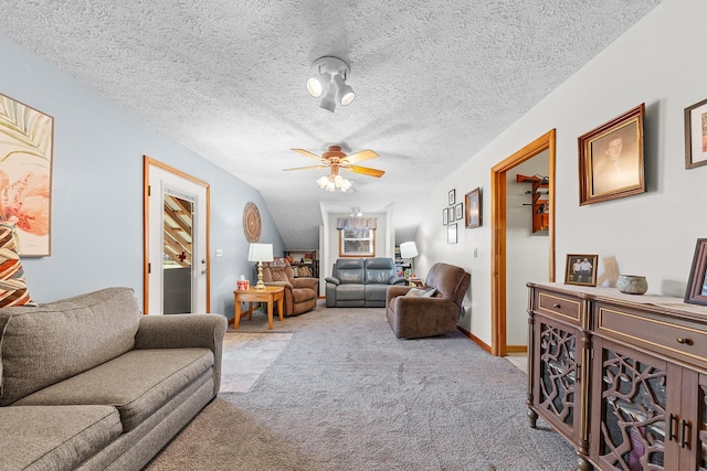 living room featuring light carpet, ceiling fan, a textured ceiling, and baseboards