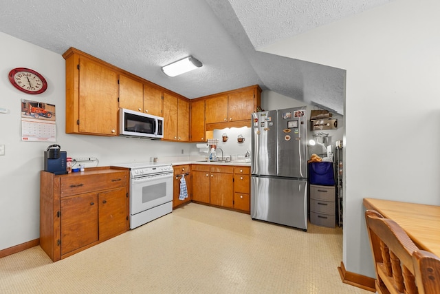 kitchen featuring light countertops, brown cabinetry, white range with electric cooktop, and freestanding refrigerator