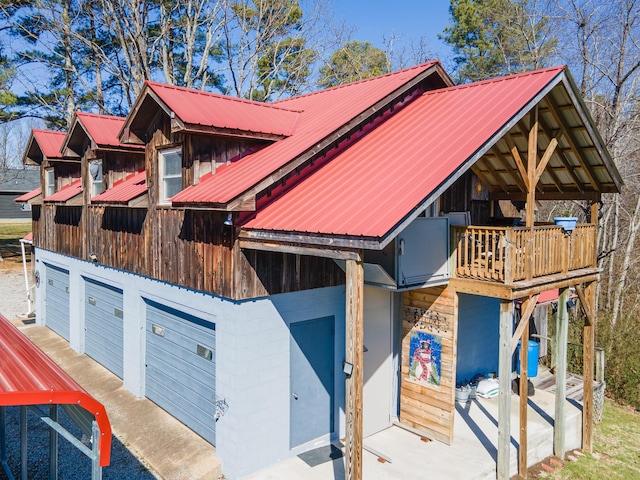 view of front of property with a garage, metal roof, and a balcony