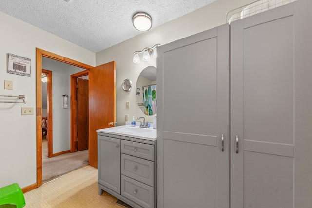 full bath with baseboards, a textured ceiling, and vanity