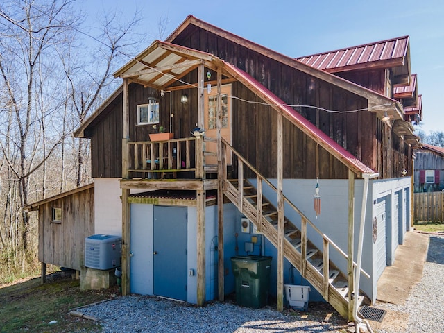 back of property with metal roof and stairway