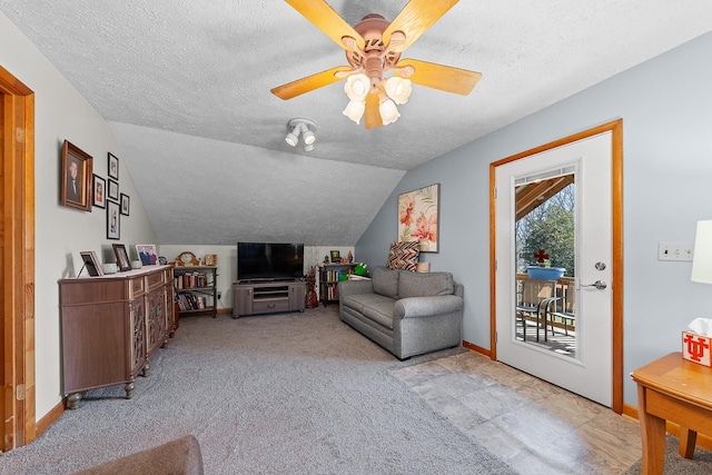 living area with lofted ceiling, light colored carpet, ceiling fan, a textured ceiling, and baseboards