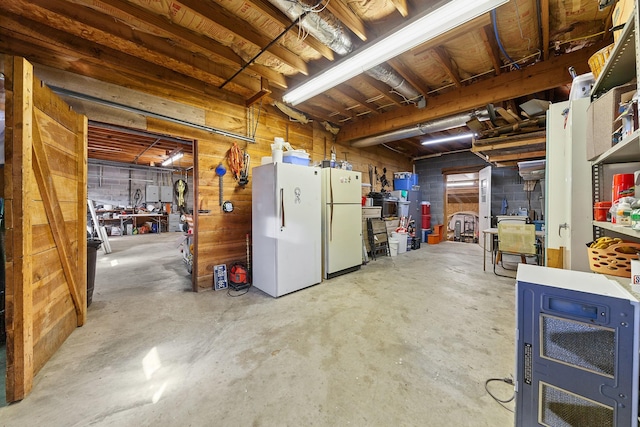 unfinished basement featuring freestanding refrigerator