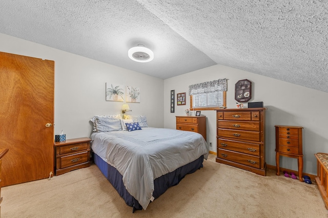 bedroom with lofted ceiling, a textured ceiling, and light colored carpet