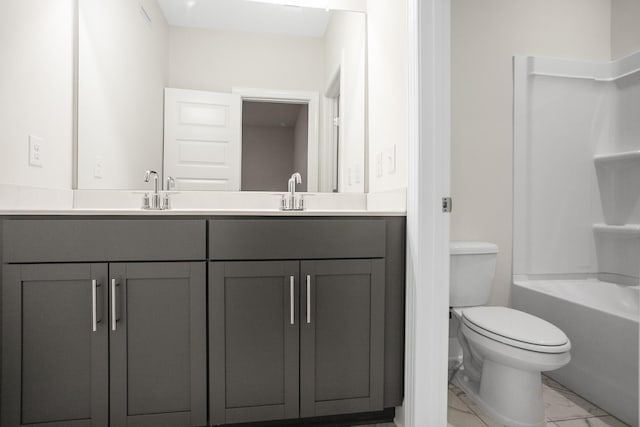 full bathroom with marble finish floor, a sink, toilet, and double vanity