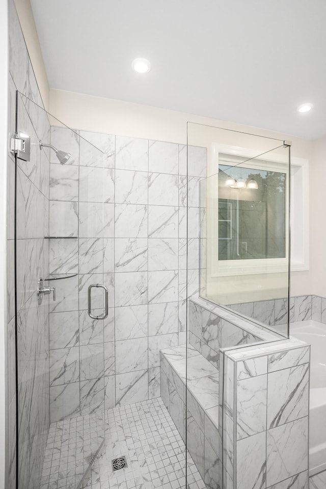 bathroom with recessed lighting, a garden tub, and a shower stall