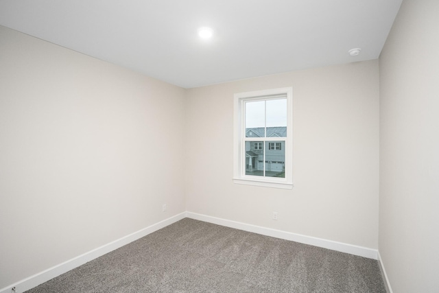 carpeted spare room with baseboards