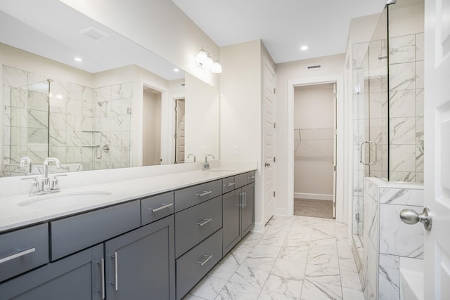 full bath featuring marble finish floor, a spacious closet, a sink, and a shower stall