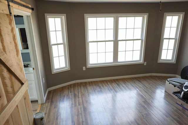 1335 Bumpus Mills Rd, Dover, TN 37058 - interior space with a barn door, baseboards, and light wood-style flooring