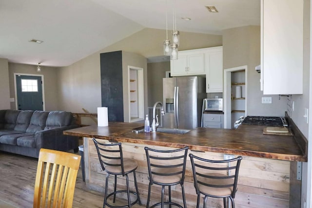 1335 Bumpus Mills Rd, Dover, TN 37058 - kitchen featuring wood finished floors, lofted ceiling, a sink, white cabinets, and stainless steel refrigerator with ice dispenser