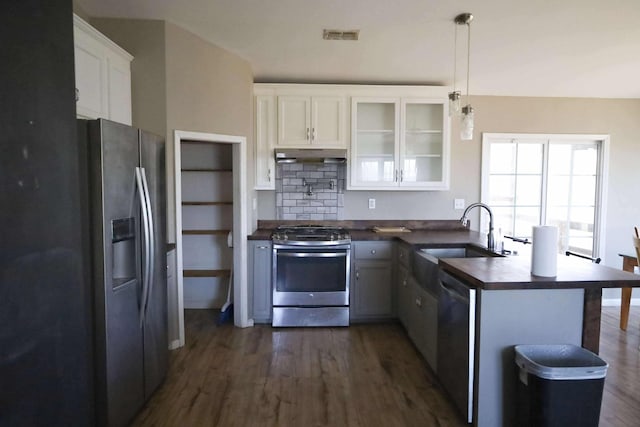 1335 Bumpus Mills Rd, Dover, TN 37058 - kitchen featuring dark countertops, under cabinet range hood, appliances with stainless steel finishes, a peninsula, and a sink