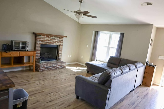 1335 Bumpus Mills Rd, Dover, TN 37058 - living area featuring wood finished floors, a ceiling fan, visible vents, a fireplace, and vaulted ceiling