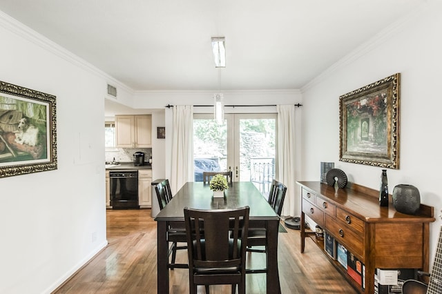 dining room with french doors, dark wood finished floors, visible vents, ornamental molding, and baseboards