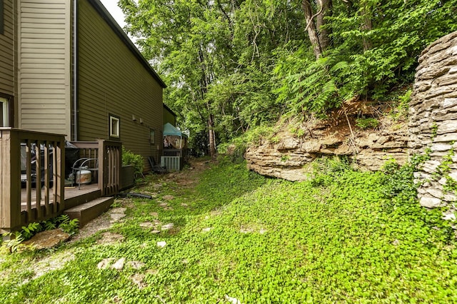 view of yard featuring cooling unit and a deck