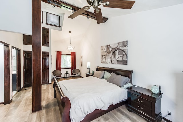 bedroom with ceiling fan, high vaulted ceiling, and wood finished floors